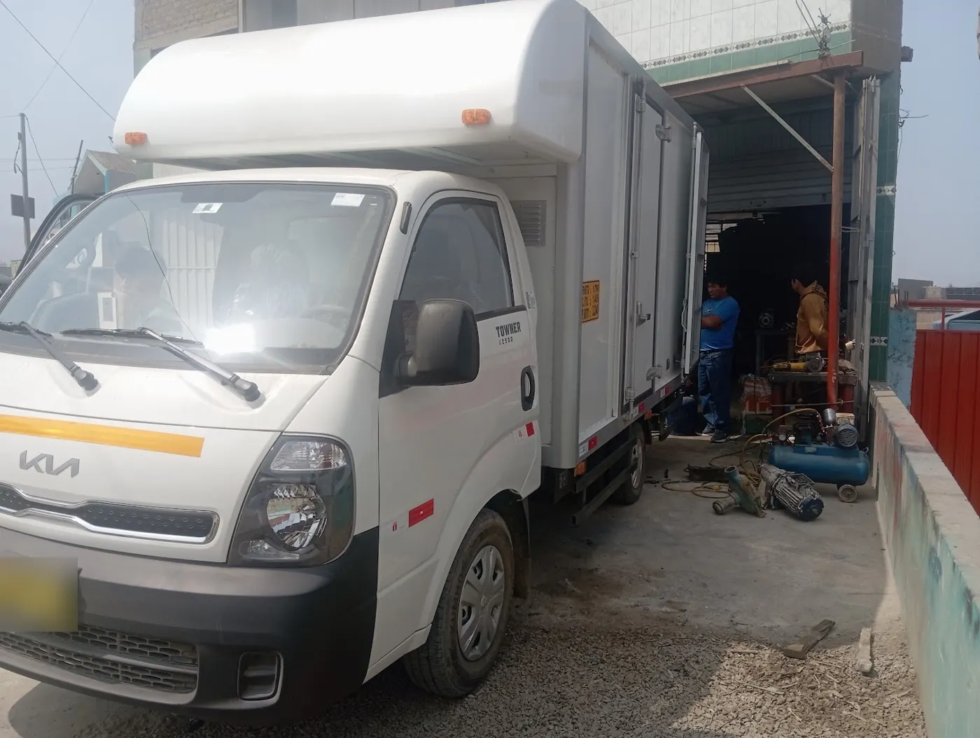 Camión de reparto cargando en la planta